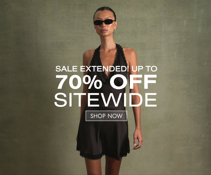 Woman wearing a WeWoreWhat dark brown silk dress with sunglasses on a green background and sale text overlay.